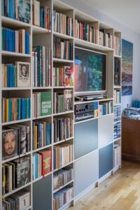 A photograph of an entertainment center with a TV surrounded by bookshelves.