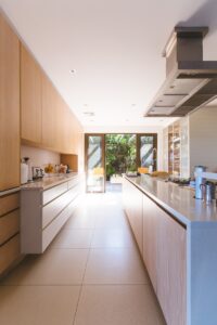 A photo of a galley-style kitchen with light hardwood cabinets.