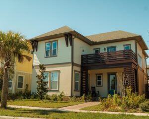 Photo of the exterior of a two story home with a wooden balcony over the front door.